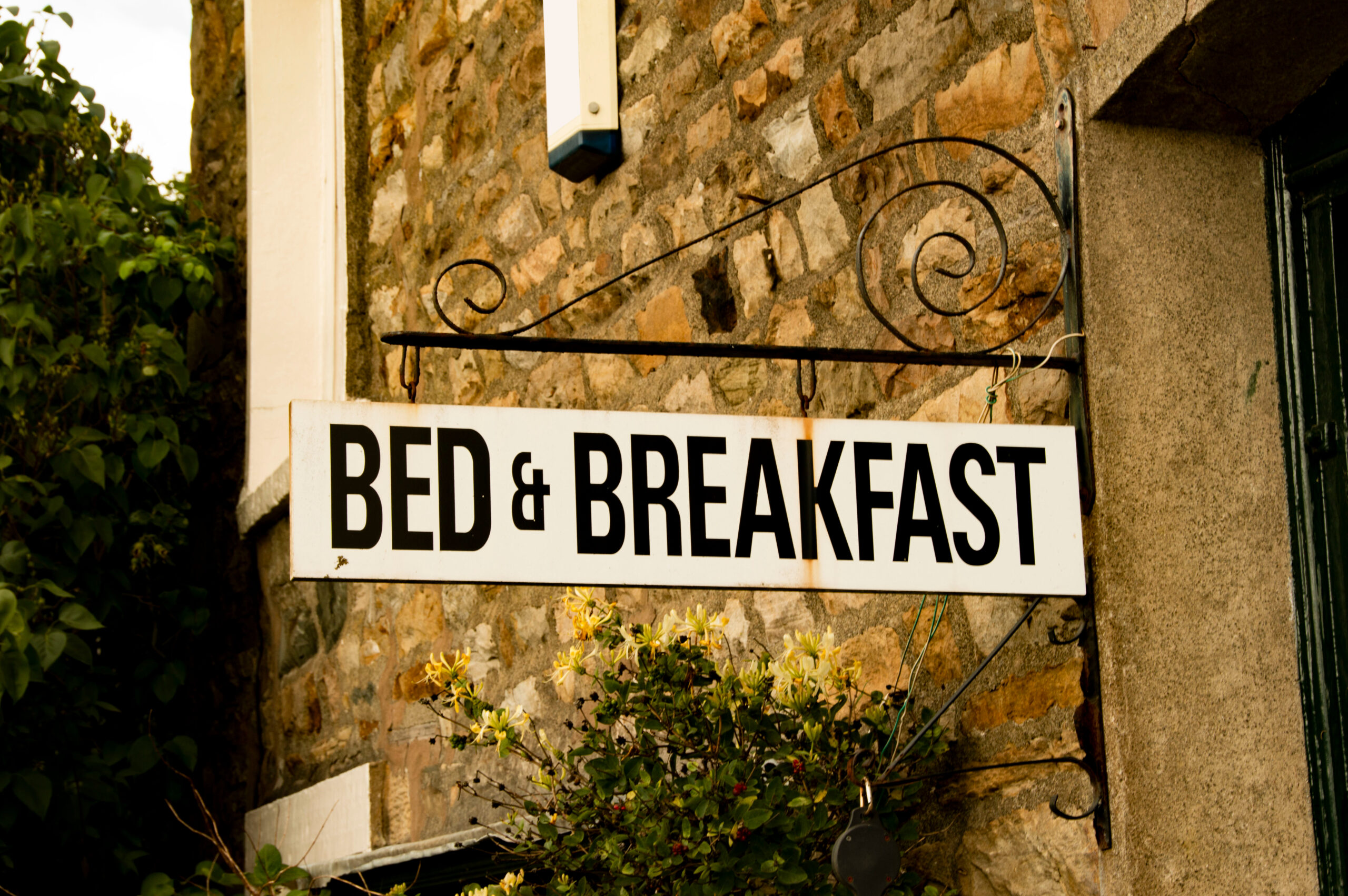 Vintage,Bed,&amp;,Breakfast,Sign,Attached,To,Rustic,Brick,Building