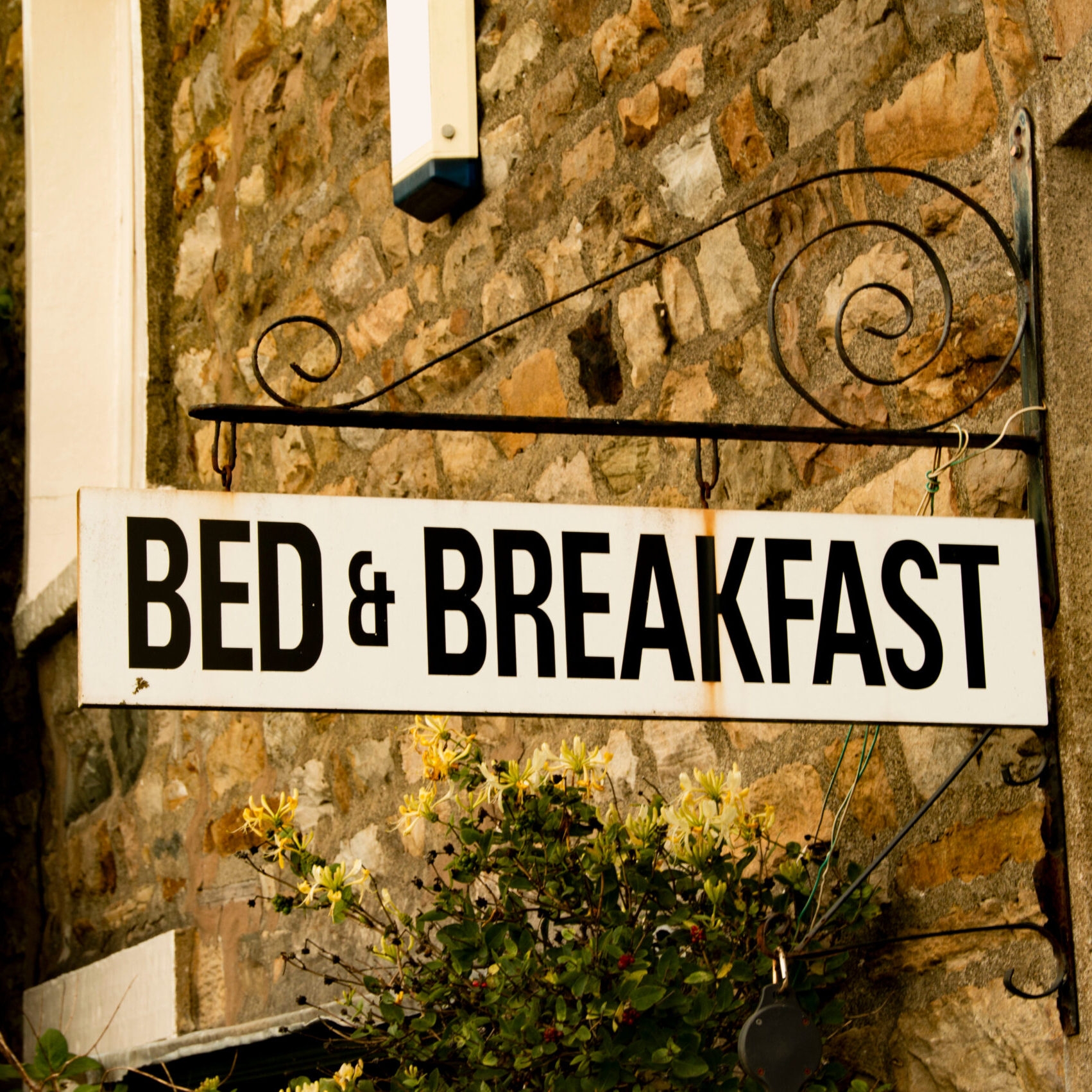 Vintage,Bed,&amp;,Breakfast,Sign,Attached,To,Rustic,Brick,Building